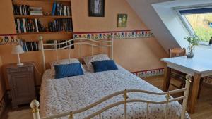 a bedroom with a white bed with blue pillows at les HAUTS de SAINT SATURNIN in Saint-Saturnin