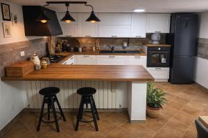 a kitchen with white cabinets and a counter with stools at Casa Maria in Scauri