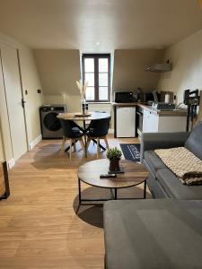 a living room with a couch and a table at Appartement de Charmes dans le Centre de Cherre in Cherré
