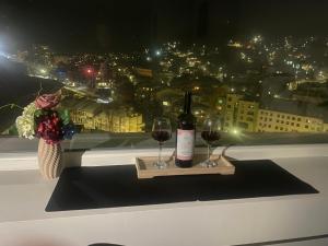 a bottle of wine and two glasses on a table at BALKAN TOWER- Apartment Viktoria in Gabrovo