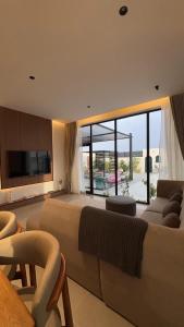 a large bedroom with a large bed and a couch at Areenachalet in Ibrā