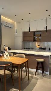 a kitchen with a wooden table and chairs and a counter at Areenachalet in Ibrā +16 photos