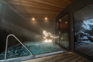 a swimming pool in a house with a window at The Alpina Mountain Resort in Tschiertschen