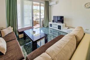 a living room with a couch and a table at Panorama Sky Apartment in Sarandë