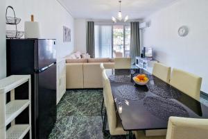 a kitchen and living room with a table and a couch at Panorama Sky Apartment in Sarandë