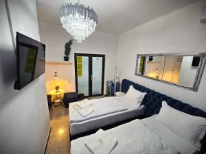 a bedroom with two beds and a chandelier at Perfect Ploiesti in Ploieşti