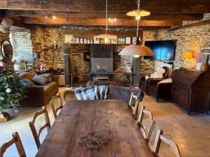 a living room with a wooden table and a fireplace at La Roulière en Aubrac in Montpeyroux