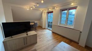 a living room with a flat screen tv on a cabinet at Ferienwohnung Roseggersiedlung in Murau