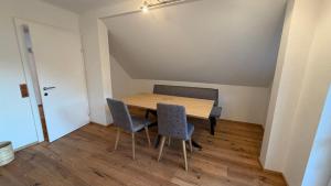 a dining room with a wooden table and two chairs at Ferienwohnung Roseggersiedlung in Murau