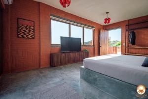 a bedroom with a bed and a flat screen tv at Coyote, 7BR Ocean View Villa, 2 Pools, Zipolite in Puerto Ángel