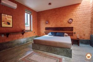 a bedroom with a bed and a brick wall at Coyote, 7BR Ocean View Villa, 2 Pools, Zipolite in Puerto Ángel +64 photos