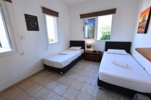 two beds in a room with two windows at GREAT VILLA MARIA in Paralimni +38 photos