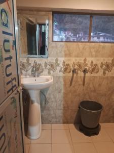 a bathroom with a sink and a toilet and a window at Krishna Homestay in Bhowāli