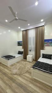 a bedroom with two beds and a rug at شالية مزايا الاشخرة in Al Sharqiyah