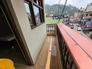 a balcony of a building with a view of a street at Krishna Homestay in Bhowāli
