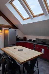 a kitchen with a wooden table and a skylight at L'industriel - meublé de tourisme 4 étoiles in Fécamp