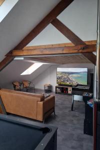 a living room with a couch and a flat screen tv at L'industriel - meublé de tourisme 4 étoiles in Fécamp