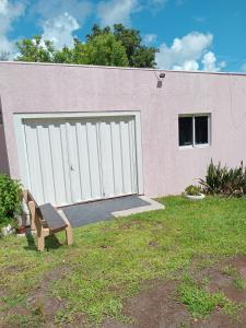 a bench in front of a building with a garage at Casa Rosa in Frederico Westphalen