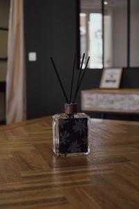 a glass container with sticks in it sitting on a table at Les Suites Gueguen in Chablis +27 photos