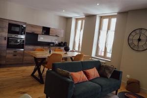 a living room with a couch and a table at Les Suites Gueguen in Chablis