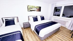 a bedroom with two beds and a window at Ioana Homes Ferienwohnung in Abstatt