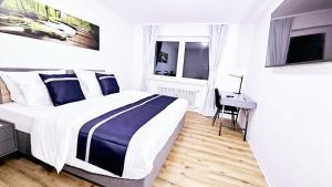 a bedroom with a bed and a desk in it at Ioana Homes Ferienwohnung in Abstatt +12 photos