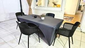 a table with black chairs and a gray table cloth at Ioana Homes Ferienwohnung in Abstatt