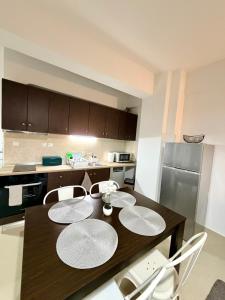 a kitchen with a wooden table and white chairs at Beauty Home Orestiada Center in Orestiada +44 photos