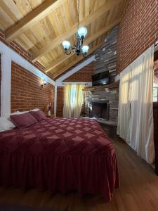 a bedroom with a red bed and a brick wall at Del Cortes Cabañas in Velasco