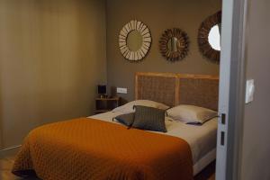 a bedroom with a bed with two mirrors on the wall at Les Suites Gueguen in Chablis