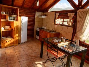 a kitchen with a table and a refrigerator at Aventurados in Potrerillos +33 photos