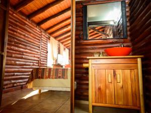 a bathroom with a sink and a mirror on a wooden wall at Aventurados in Potrerillos