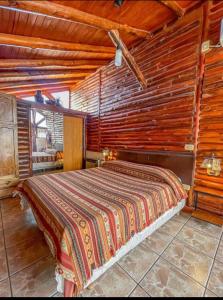 a bedroom with a bed in a log cabin at Aventurados in Potrerillos