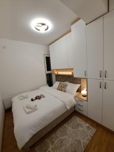 a bedroom with a bed and white cabinets at Tiha noć II Vrnjačka Banja in Vrnjačka Banja