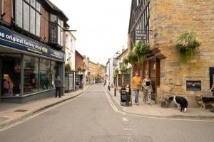 a city street with people and dogs standing on the sidewalk at Apartment ONE in Sherborne