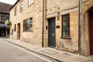 a brick building with a black door on a street at Apartment ONE in Sherborne