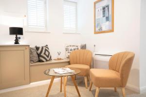 a living room with two chairs and a table at Apartment ONE in Sherborne