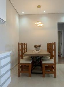 a dining room with a wooden table and chairs at Casa aconchego in Socorro