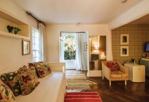 a living room with a couch and a window at TW Guaimbê Exclusive Suítes in Ilhabela