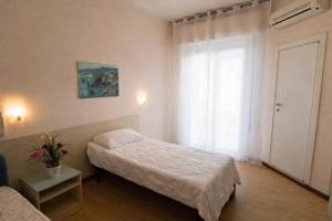 a small bedroom with a bed and a window at Hotel Dante in Cattolica +36 photos