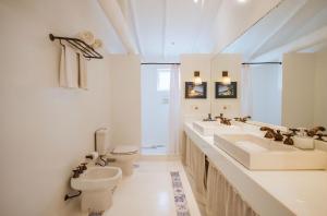 a white bathroom with two sinks and a toilet at TW Guaimbê Exclusive Suítes in Ilhabela +45 photos