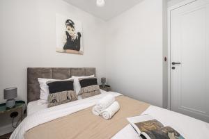 a bedroom with a bed with a portrait of a man at Lumina I Premium 3BR Apartment with Balcony I City View in Warsaw +24 photos