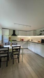 a large kitchen with a table and chairs in it at Cottage by the river Valea Draganului in Poeni