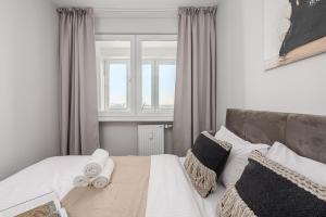 a bedroom with a bed with white sheets and pillows at Lumina I Premium 3BR Apartment with Balcony I City View in Warsaw