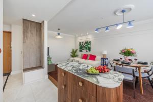 a kitchen and living room with a bowl of fruit on a counter at Lumina I Premium 3BR Apartment with Balcony I City View in Warsaw