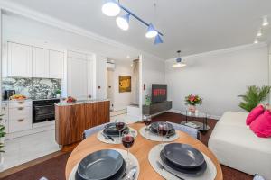 a living room with a table with glasses of wine at Lumina I Premium 3BR Apartment with Balcony I City View in Warsaw