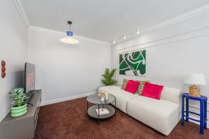 a living room with a white couch and red pillows at Lumina I Premium 3BR Apartment with Balcony I City View in Warsaw