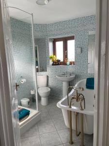 a bathroom with a tub and a toilet and a sink at Hardy View Farm House in Dorchester +68 photos