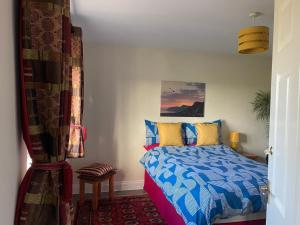 a bedroom with a bed with blue and yellow pillows at Hardy View Farm House in Dorchester