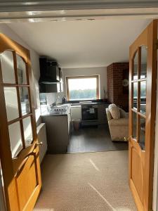 a small kitchen with a stove and a couch at Hardy View Farm House in Dorchester